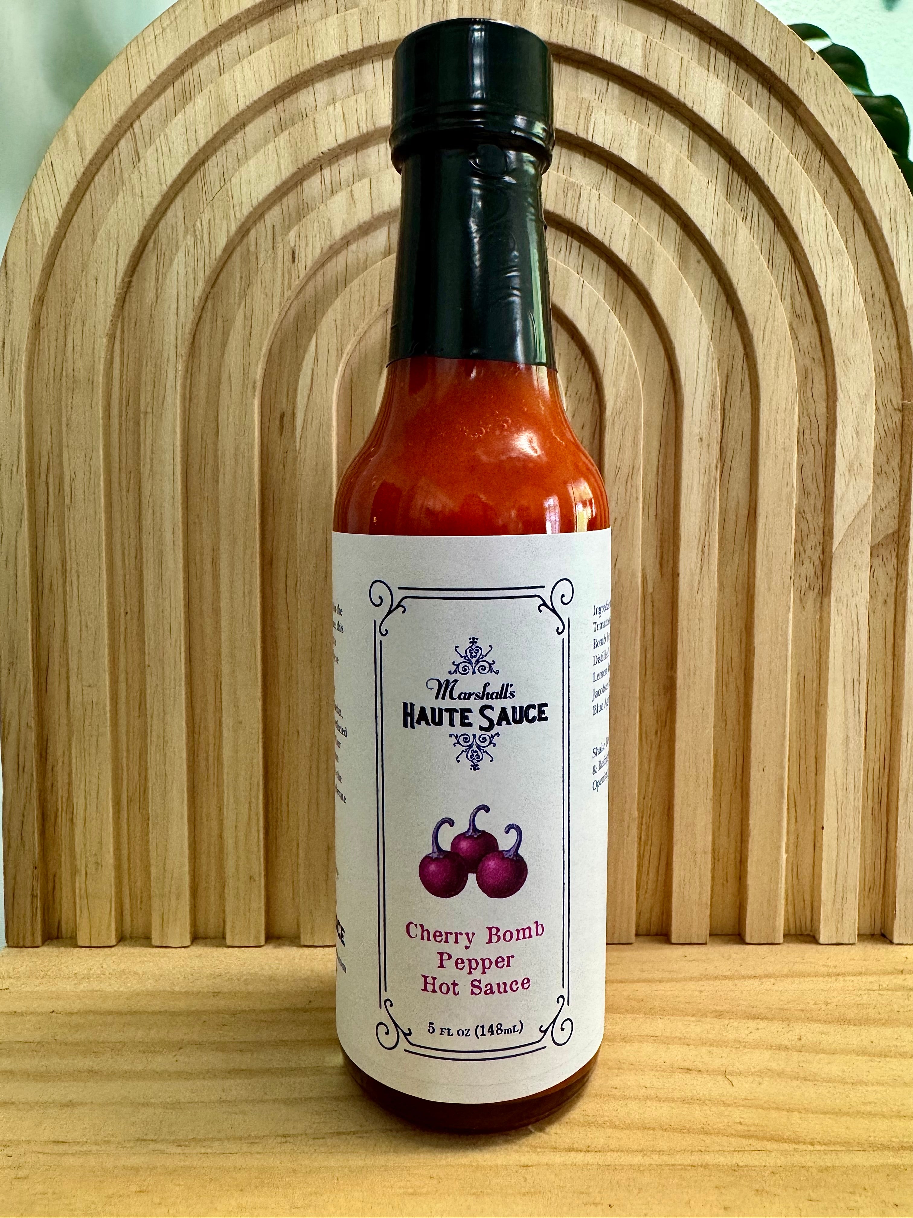 Cherry Bomb Pepper Hot Sauce bottle featuring bold flavors and a playful cherry design.