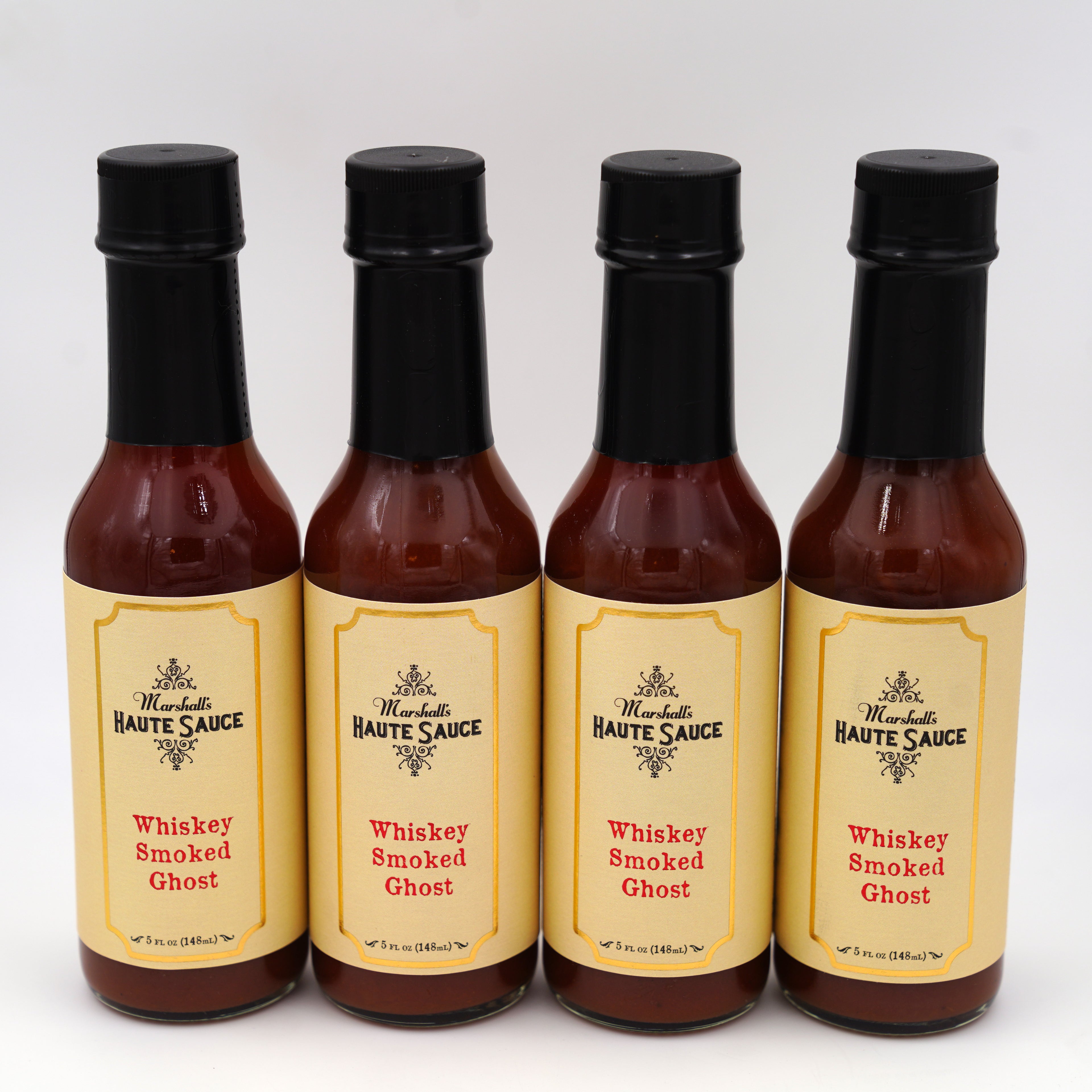 Hot Ones Season 22 Uncle Nearest Whiskey Smoked Ghost Hot Sauce 4-Pack bottles displayed together.